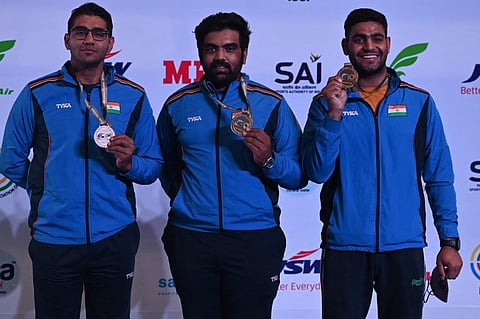 Kynan Chenai, Prithviraj Tondaiman and Lakshay Sheoran of India pose after winning gold medal in trap team men’s final of ISSF World Cup 2021, at Karni Singh shooting range in New Delhi. (Photo | AFP)