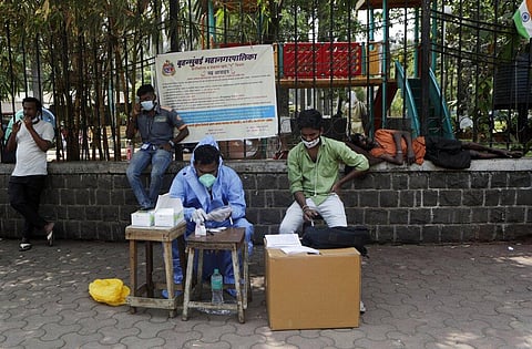 A health workers waits to conduct tests for COVID-19 at a roadside camp in Mumbai, India, Thursday, March 25, 2021. (Photo | AP)