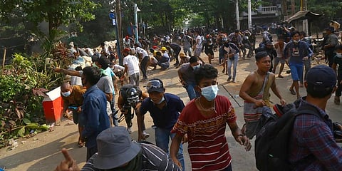 Anti-coup protesters disperse as the protesters confront police in Yangon, Myanmar. (Photo | AP)