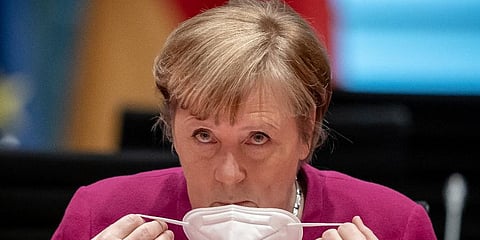 German Chancellor Angela Merkel takes off her mask at the beginning of the Federal Cabinet meeting at the Chancellery in Berlin, Germany. (Photo | AP)