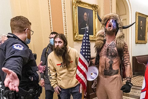 Supporters of President Donald Trump, including Jacob Chansley, right with fur hat, are confronted by U.S. Capitol Police officers outside the Senate Chamber inside the Capitol in Washington (AP)