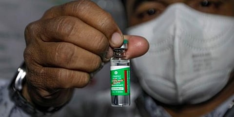 A health workers holds up a Covishield vial. (Photo | EPS)