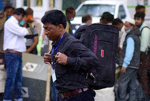 Polling Officials walk in the rain as they collect EVMs and other polling materials ahead of the second phase of the Assam Assembly elections, in Nagaon on Wednesday. (Photo | ANI)
