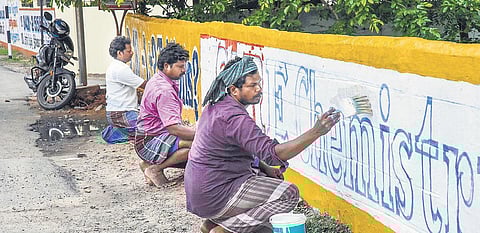 Graffiti artists painting a compound wall at Thennur in Tiruchy | M K Ashok Kumar