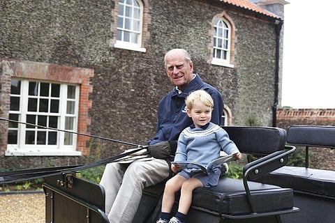 In this undated handout photo provided by the Duke and Duchess of Cambridge, Britain's Prince Philip sits with his great-grandson Prince George in England. (Photo | AP)