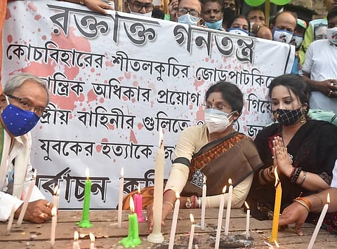 TMC candidate from Shyampukur constituency, Sashi Panja, with her party associates paying candle light tribute who lost their life at a polling booth of Sitalkuchi. (Photo | PTI)