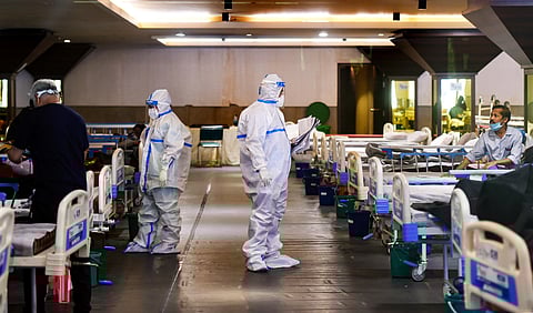 Medics attend to a COVID-19 patients at Shehnai Banquet Hall, temporarily converted into an isolation ward near LNJP Hospital in New Delhi on Tuesday. (Photo | PTI)