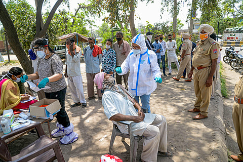 A health worker take nasal sample of commuters for Covid-19 test, amid rise in coronavirus cases across country on Tuesday. (Photo | PTI)