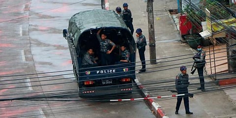 Police security forces stand by inside a police vehicle and on the sidewalk of Hledan Road in Kamayut township in Yangon, Myanmar. (Photo | AP)
