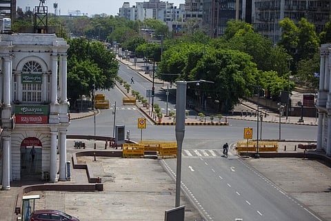 A cyclist pedals past a deserted street during a weekend lockdown in New Delhi. (File photo| AP)