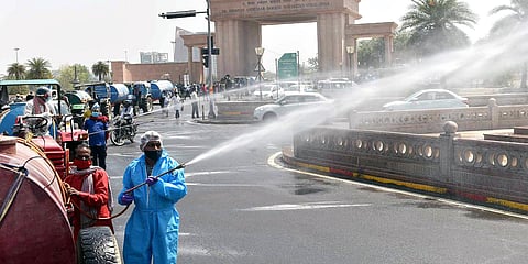 A team of Lucknow Municipal Corporation sprays disinfectant during the weekend lockdown. (Photo| ANI)