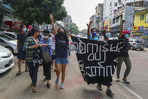 Anti-coup protesters shout slogan with a banner reading ''Carry on revolution! We do not accept as the military slave,'' in Kamayut township of Yangon, Myanmar. (Photo | AP)