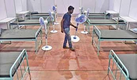 A worker makes arrangements at the Koramangala Indoor stadium, in Bengaluru, a Covid Care Centre. (Photo| Ashish Krishna)