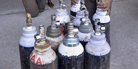 Workers arrange oxygen cylinders being transported to hospital for Covid-19 patients. (Photo | PTI)