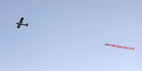 A plane with a 'Say No To Super League' banner flies over Elland Road, as a protest against Liverpool's decision to be included amongst the clubs attempting to form a new Super League, in Leeds. (AP)