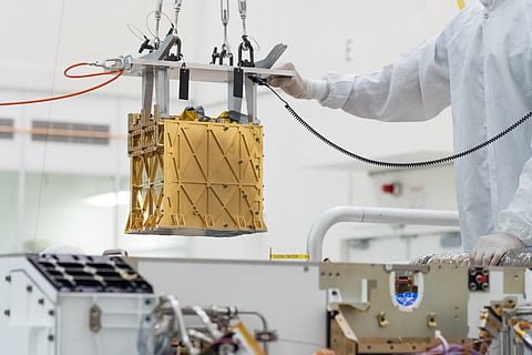 Technicians carefully lowering MOXIE instrument into the belly of the Perseverance rover in the cleanroom at NASA's Jet Propulsion Laboratory, in Pasadena, California in March 2019. (Photo | AP)