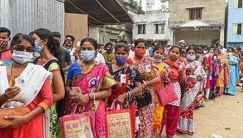 People stand in a queue to cast their vote at a polling station during the 6th phase of State Assembly Election at Birati, in North 24 Parganas (Photo | PTI)