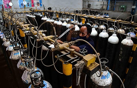 A worker inspects oxygen cylinders at a facility before they are sent to hospitals. (Photo | Ashishkrishna HP, EPS)