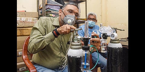 Social activist Gaurav Rai, popularly known as Oxygen Man' installs cylinders for the patients who are home-quarantined due to COVID-19, in Patna. (Photo | PTI)