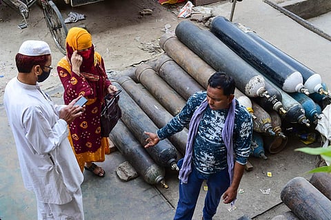 Relatives of COVID-19 patients enquire about the availability of medical oxygen cylinders at a filling center, as demand for the gas rose due to a spike in coronavirus cases, in New Delhi. (Photo | PT