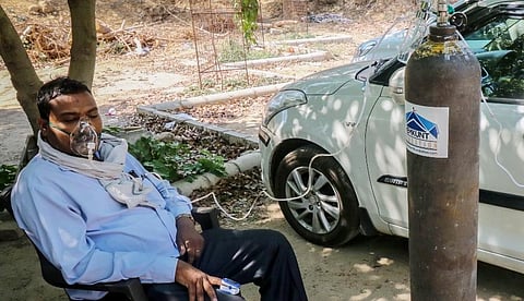 A COVID-19 patient uses an oxygen cylinder from an NGO Hemkunt Foundation, which is offering free oxygen cylinders for COVID 19 patients, in Gurugram. (Photo | PTI)