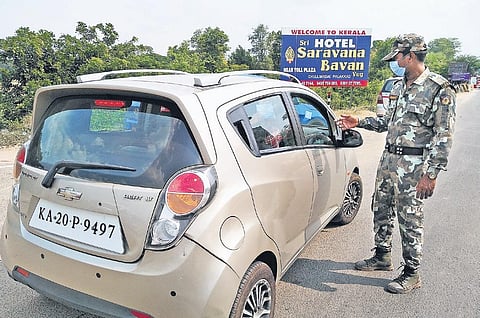 Police inspect documents and explain rules of inter-state travel to inbound passengers at the Kerala-Tamil Nadu border| Express