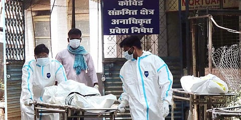 Health workers carry a COVID-19 patient's body for cremation, at a mortuary, in Bhopal. (Photo | ANI)