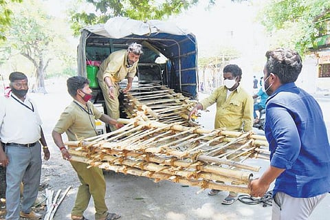 Workers of the Mysuru City Corporation load bamboo biers on to a tempo to be transported to crematoriums on Sunday. (Photo | Udayshankar S, EPS)