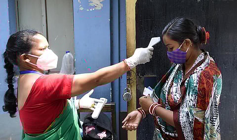A voter undergoes thermal screening at a polling booth during the 7th phase of West Bengal State Assembly polls in Kolkata on Monday. (Photo | PTI)