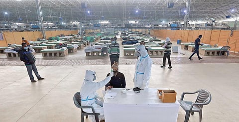 A health worker checks the temperature of a patient at Sardar Patel Covid Care Centre on Saturday. (Photo | Shekhar Yadav, EPS)