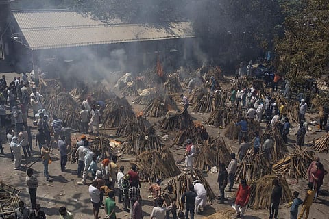 Multiple funeral pyres of those who died of COVID-19 burn at a ground that has been converted into a crematorium for the mass cremation of coronavirus victims, in New Delhi. (Photo | AP)