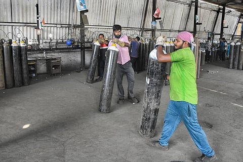 Workers sort cylinders containing medical oxygen, as its demand rises due to spike in coronavirus cases, in Surat. (Photo | PTI)