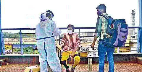 A health worker collects swab samples on the overbridge connecting the Majestic Bus Terminus and KSR Railway Station in Bengaluru on Monday | ASHISHKRISHNA HP