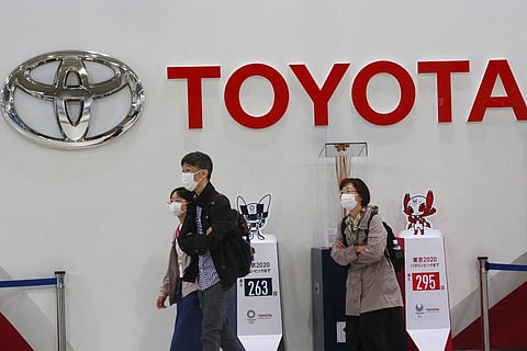 Visitors walk at a Toyota showroom in Tokyo. (Photo | AP)