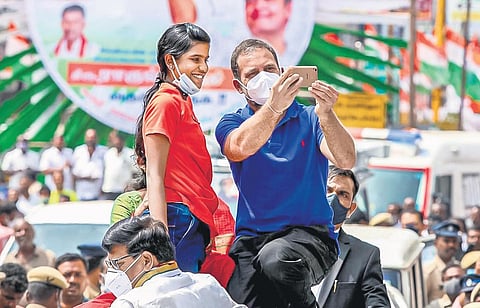 Congress leader Rahul Gandhi posing for a selfie with a girl at a campaign rally in Karur on Monday. (Photo | Special arrangement)