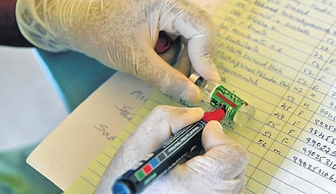 A health worker marks a vial during the vaccination drive at CV Raman Nagar Hospital in Bengaluru on Friday | Meghana Sastry