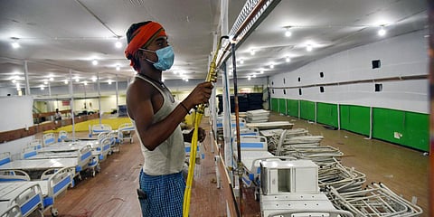 Workers construct a 100 bed ICU temporary Covid care centre at Patliputra Sports Complex in Patna. (Photo| ANI)