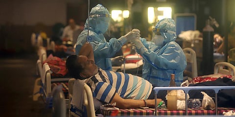 Health workers attend to COVID-19 patients at a makeshift hospital in New Delhi. (Photo| AP)