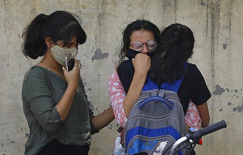Relatives of a person who died of COVID-19 mourn at a crematorium in New Delhi. (Photo | AP)