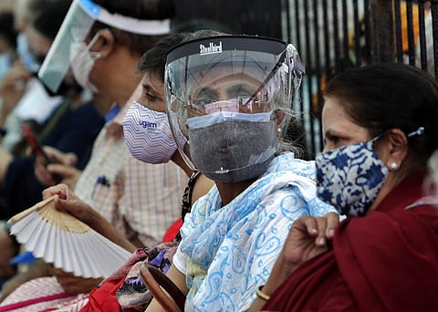 People wearing face shields and masks as a precaution against the coronavirus as they wait to receive COVID-19 vaccine in Mumbai. (Photo | AP)