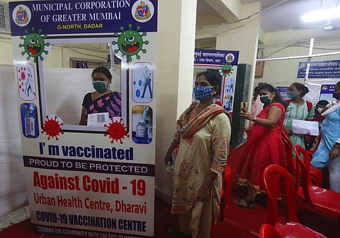 A woman gets a photograph after being administered the COVISHIELD vaccine for COVID-19 at a vaccination centre in Dharavi, Mumbai. (Photo | AP)