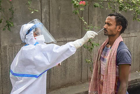 A health worker takes sample from a man for COVID-19 test, as coronavirus cases surge across the country. (Photo | PTI)