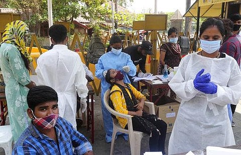 A health worker takes a nasal swab sample of a woman to test for COVID-19 near the landmark Gateway of India in Mumbai. (Photo | AP)