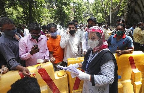 People wearing masks wait their turn for COVID-19 test outside a court in Mumbai. (Photo | AP)