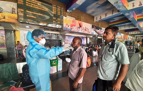 Healthcare worker testing a man for COVID-19 at Delhi railway station. (Photo | Shekhar Yadav, EPS)