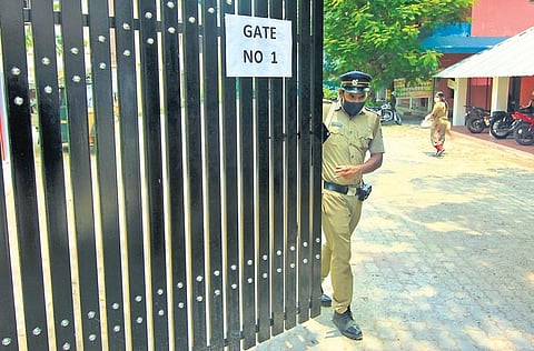 Police personnel close the gates of Government Girls Higher Secondary School, Kochi, where electronic voting machines are kept | Arun Angela