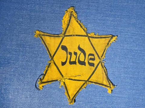 The Yellow Star badge of Heinz-Joachim Aris (Dresden 1941) reading 'Jew' is displayed in a showcase. (Photo | AP)