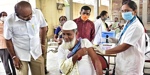 A medic injects COVID-19 vaccine to an elderly person at Gangamma Temple premises, Padmanabha Nagar area in Bengaluru. (Photo | ANI)