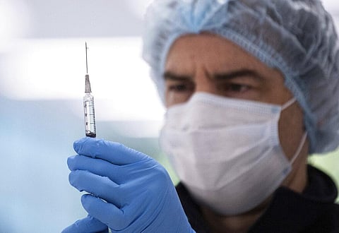 A technician prepares a Pfizer vaccine in the pharmacy area of the newly opened COVID-19 Vaccination Centre (Photo | AP)