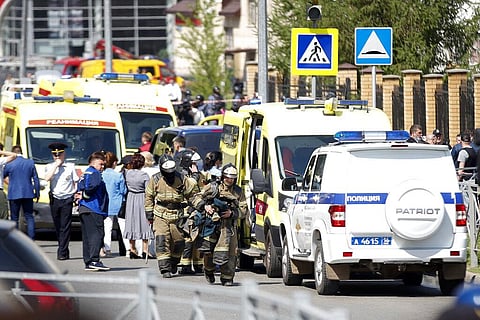 Firefighters walk past ambulances and police cars and a truck parked at a school after a shooting in Kazan, Russia, Tuesday, May 11, 2021. (Photo | AP)